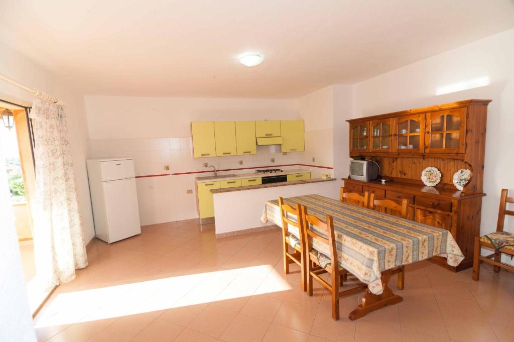 d'une cuisine avec des armoires jaunes et une table. dans l'établissement Nannis House, à Tanaunella