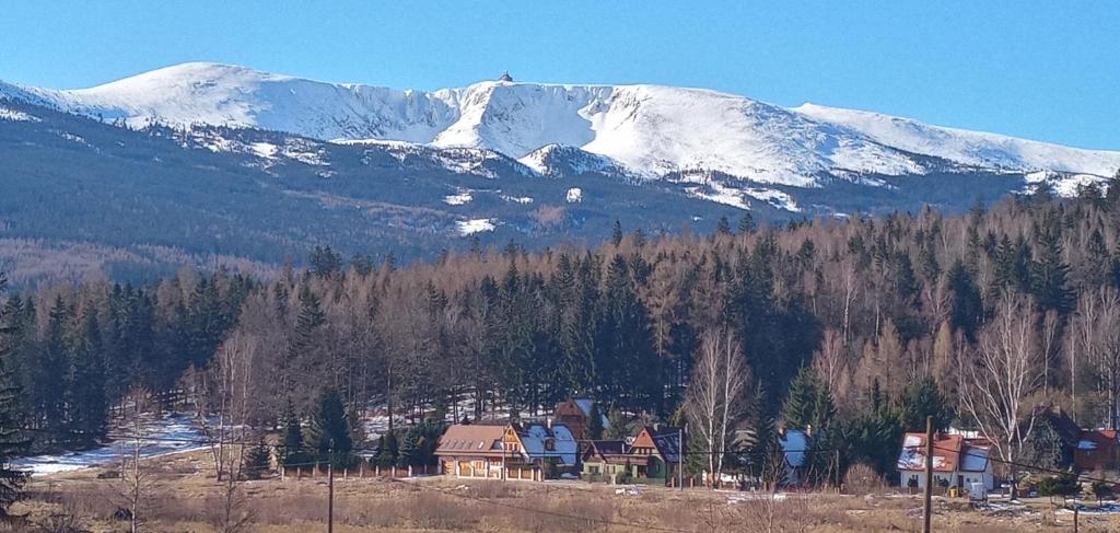 a snow covered mountain with a town and a house w obiekcie DOMEK POD ŚMIELCEM w Jagniątkowie
