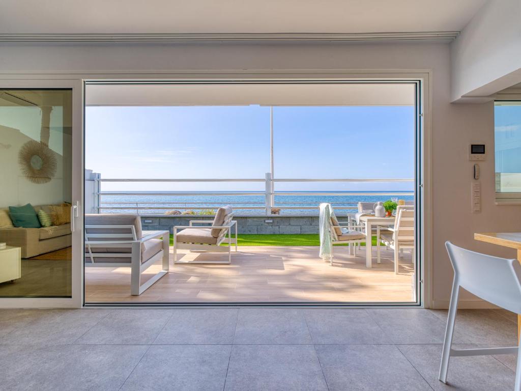 a room with a sliding glass door with a view of the ocean at Villa Isabel in Playa del Ingles
