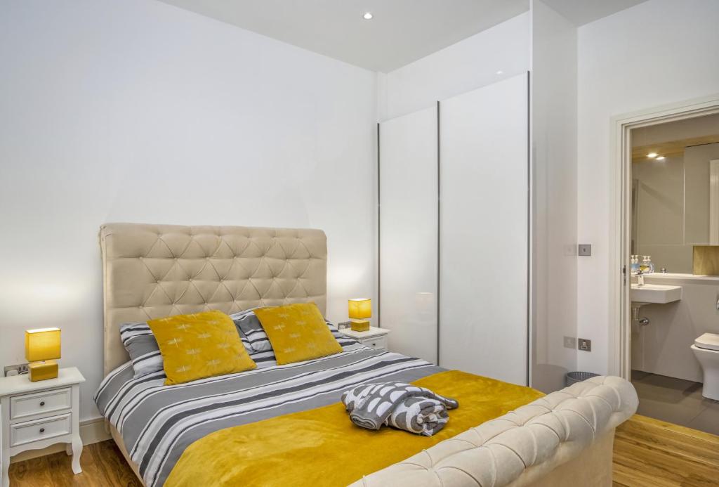 a bedroom with a large bed with yellow pillows at 602 Luxury Apartment near Luton Town and Station in Luton