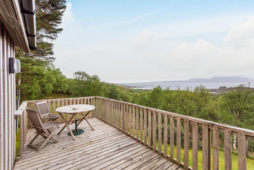 a wooden deck with a table and chairs on it at Thorsvik in Teangue