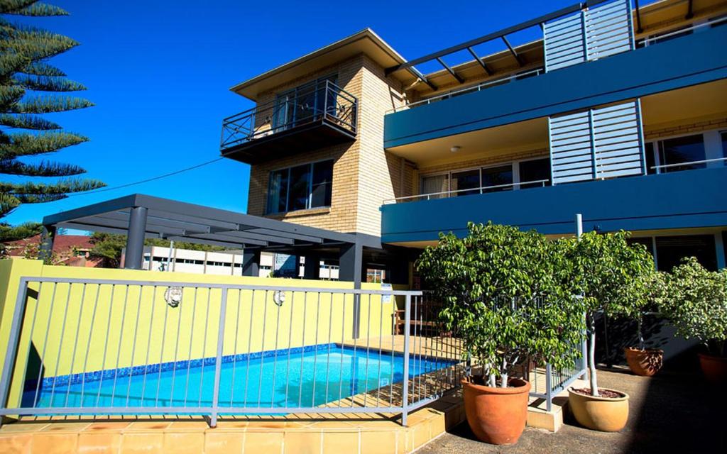 una casa con piscina frente a un edificio en Caribbean Motel, en Coffs Harbour