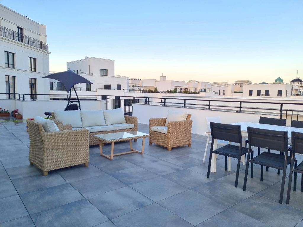 a patio with couches and tables and chairs on a roof at BELQUIS in Chessy