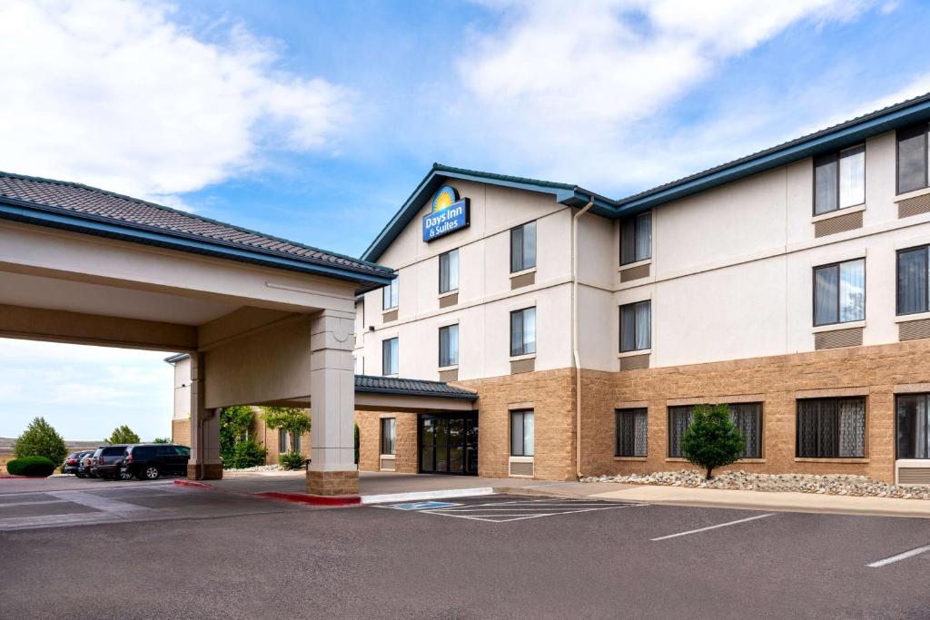 Days Inn & Suites by Wyndham Denver International Airport في دنفر: تقديم فندق بموقف