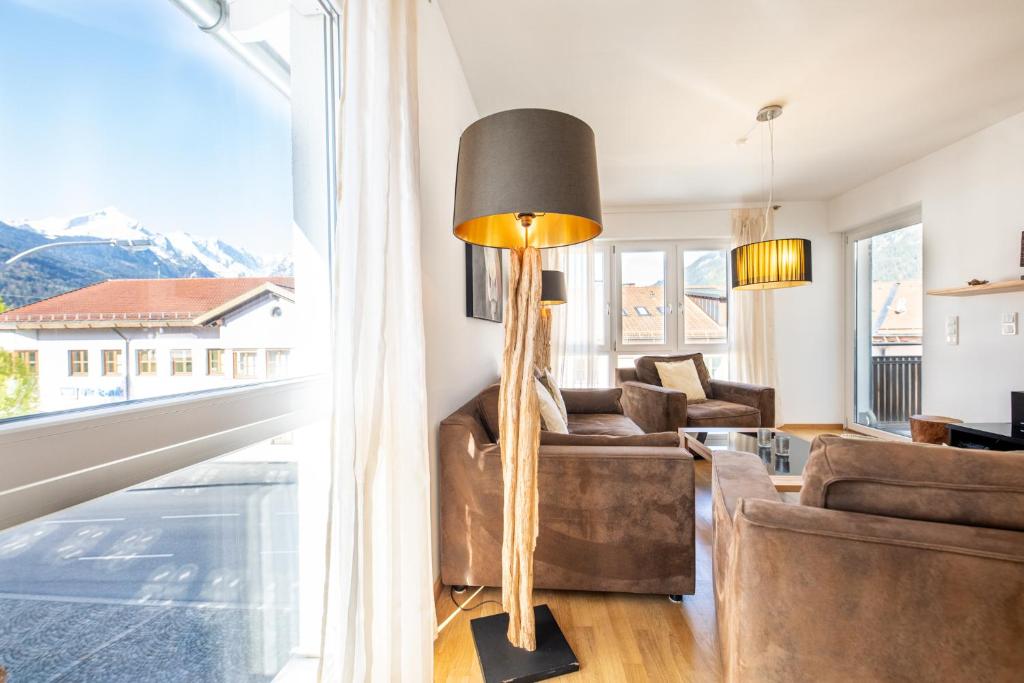 sala de estar con muebles de cuero y ventana grande en Alpenambiente, en Garmisch-Partenkirchen