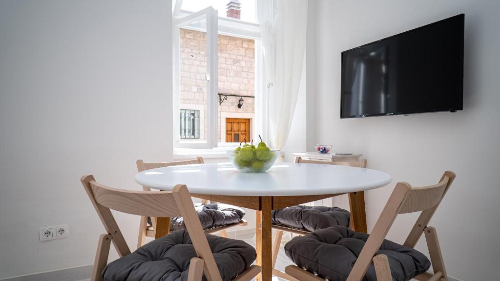 una sala da pranzo con tavolo e sedie bianchi di Max suite a Trogir