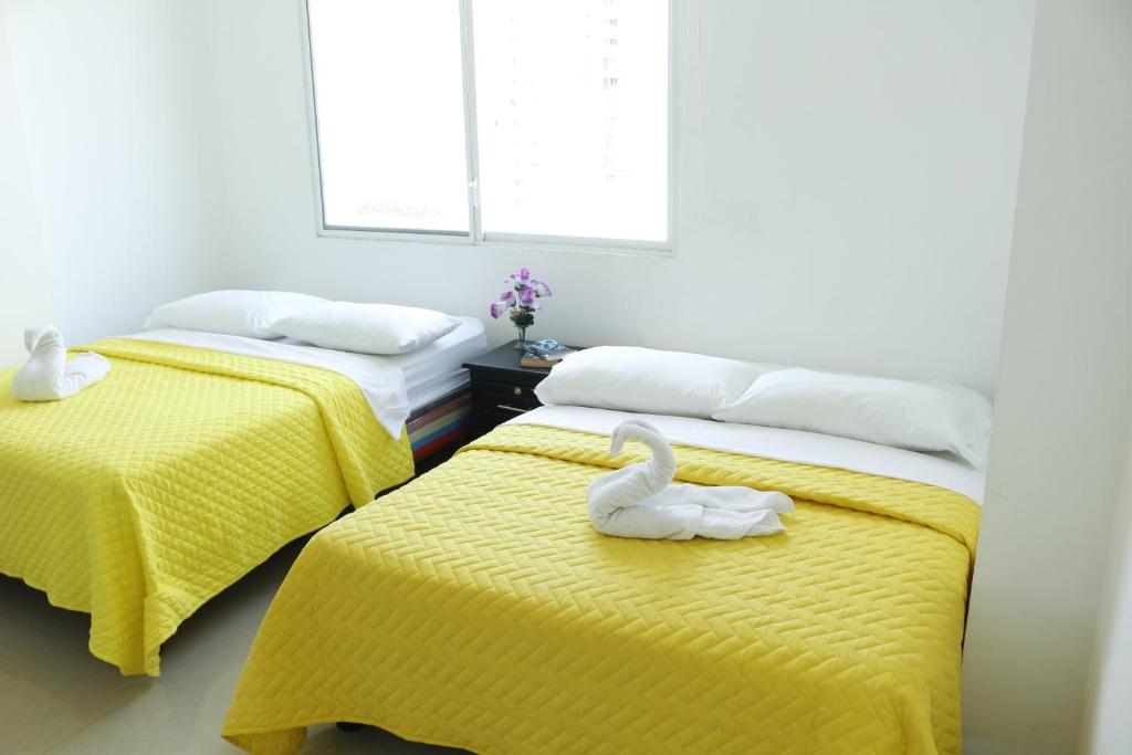 dwa łabędzie siedzące na dwóch łóżkach w pokoju w obiekcie Edificio Galatea w mieście Manta