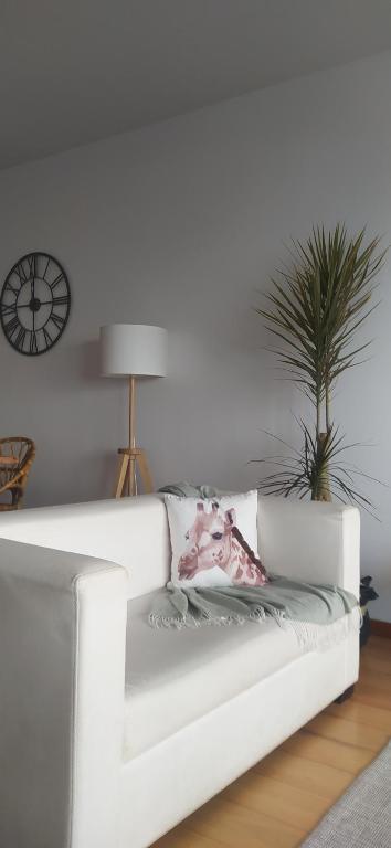 um sofá branco numa sala de estar com uma planta em AL Vista Alegre em Horta