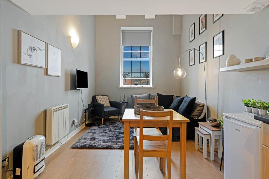 a living room with a table and a couch at Duplex 3 Bedroom Mezzanine Apartment - Heart of Edinburgh in Edinburgh
