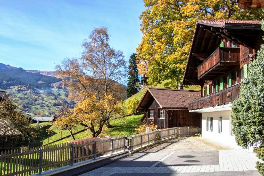 une maison avec une clôture à côté d'une montagne dans l'établissement Chalet Caroline, à Grindelwald