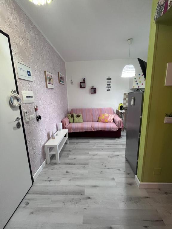 a living room with a pink couch and a refrigerator at Appartamento Affaccio sul mare, Baia di Copanello in Copanello