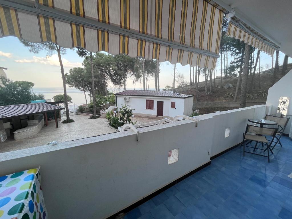 a room with a balcony with a view of a house at Appartamento Affaccio sul mare, Baia di Copanello in Copanello
