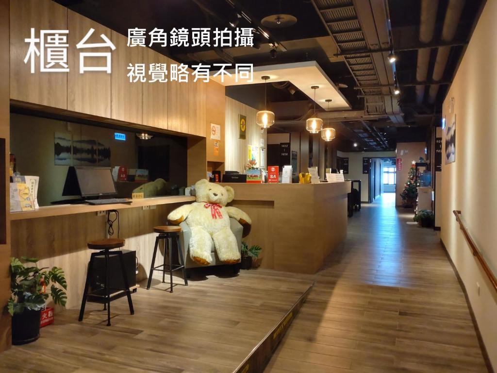 um urso de peluche sentado num balcão numa loja em Honest & Warm Hotel em Taoyuan