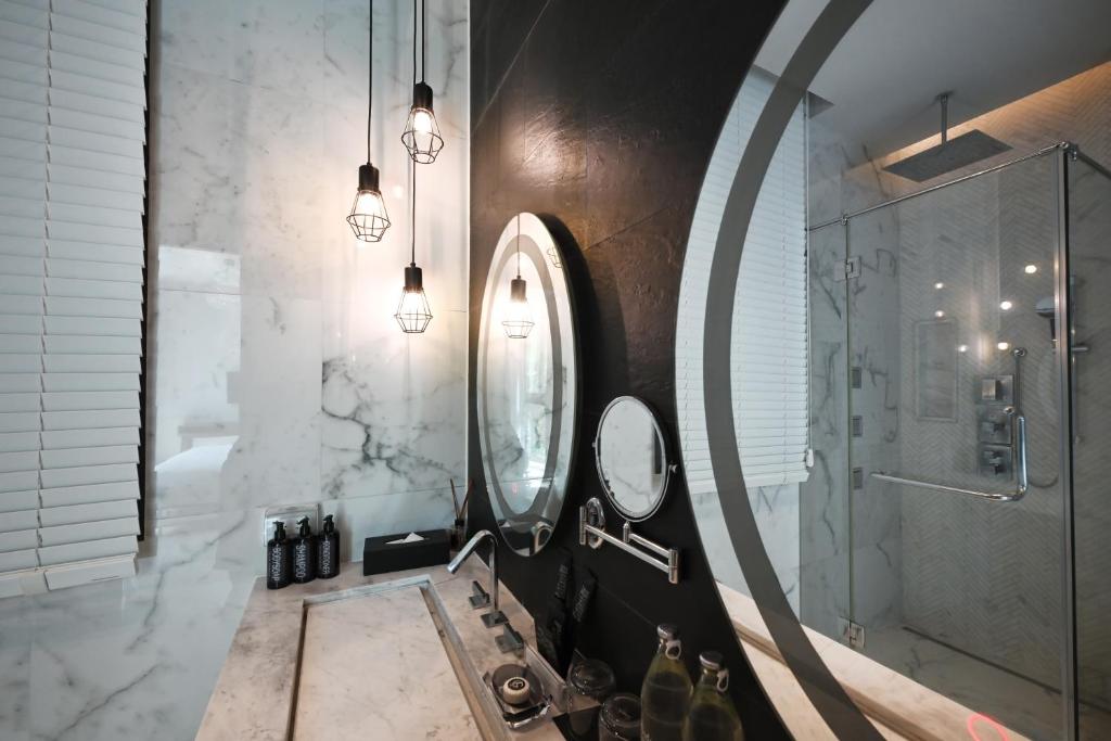 um banheiro com uma pia e um espelho em Glam Habitat - SHA Extra Plus em Kamala Beach