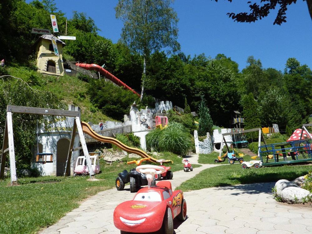 un parque con un coche de juguete y un parque infantil en Smileys Kinderhotel, en Trebesing