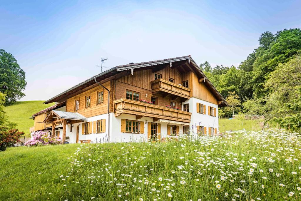 una casa en una colina con un campo de flores en Bognerlehen en Berchtesgaden