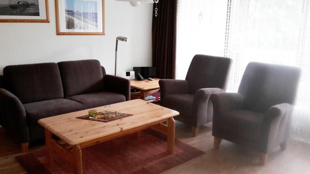 a living room with two chairs and a coffee table at Ferienwohnung Plexnies in Kellenhusen