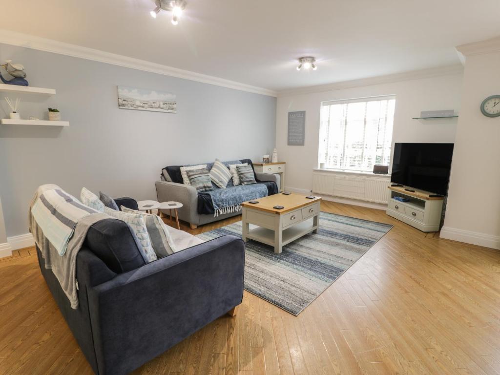 a living room with a couch and a table at Apartment 6 in Morfa Nefyn