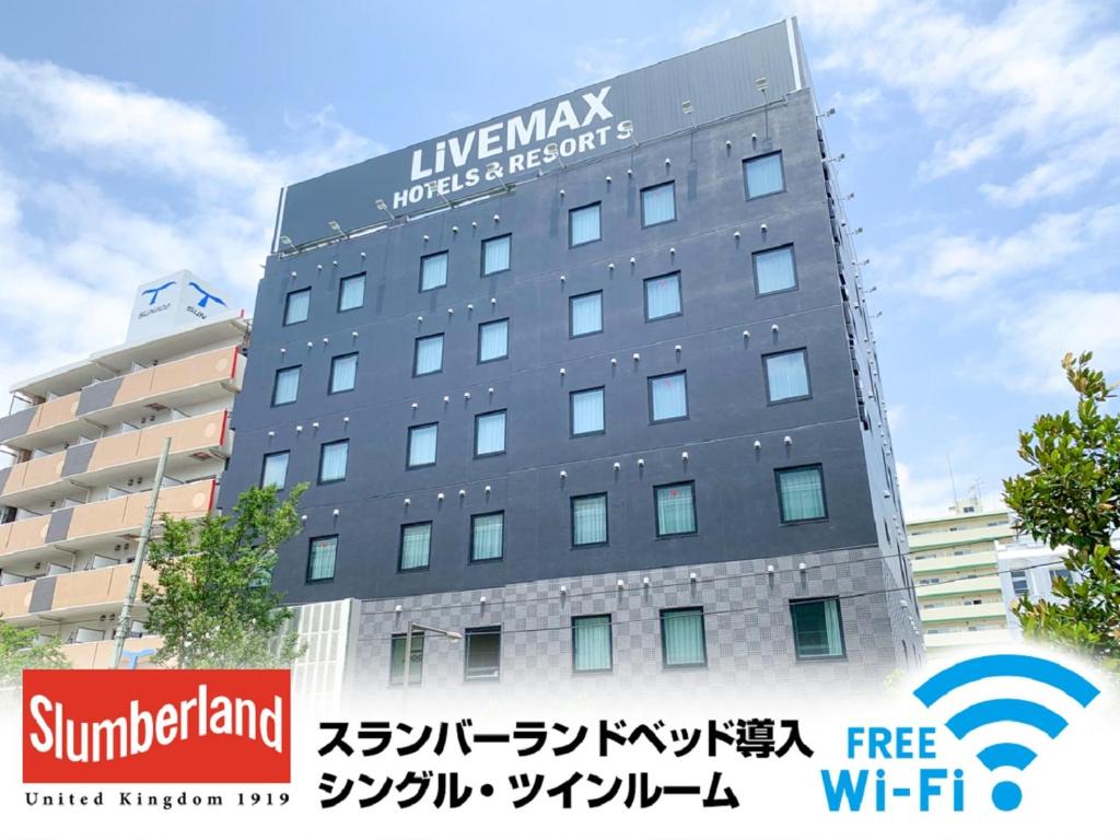 a building with a sign on the side of it at HOTEL LiVEMAX Nishinomiya in Nishinomiya