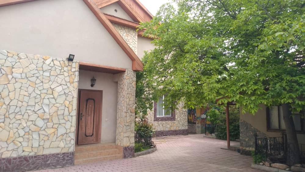 a house with a door on the side of it at Динара in Cholpon-Ata