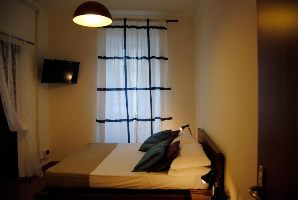 ローマにあるPapia Guest Houseのベッドルーム1室(青いカーテンと窓付きのベッド1台付)