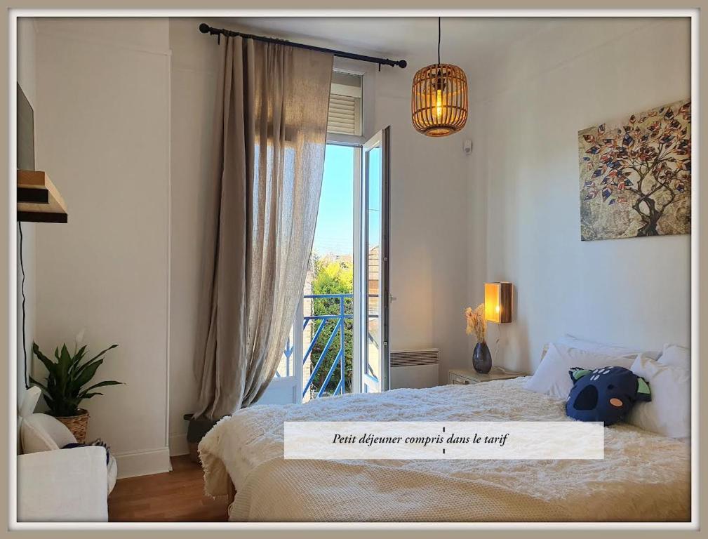 1 dormitorio con cama y ventana grande en Maison du Bonheur l Art de vivre à la française Logement entier avec parking, en Sainte-Savine