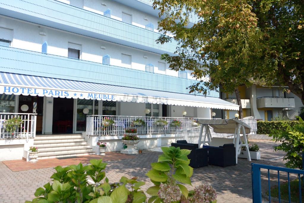 un edificio con un cartel de consejos de honorarios de hotel delante de él en Hotel Paris, en Lignano Sabbiadoro