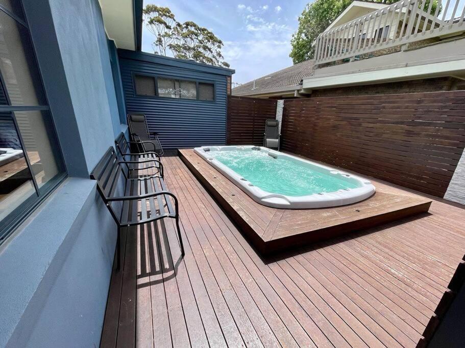 a hot tub sitting on top of a wooden deck at Sails to Sea - 4 Bedroom Pet Friendly Private Pool in Pambula Beach