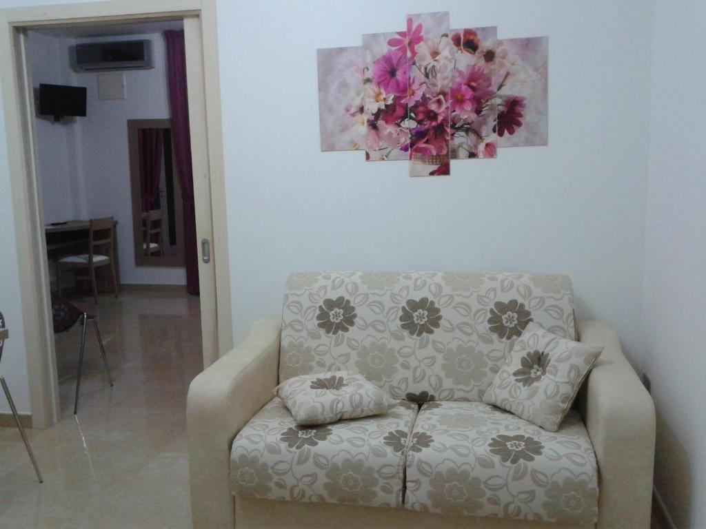 a living room with a couch and a painting on the wall at Spazi Preziosi in Torre San Giovanni Ugento