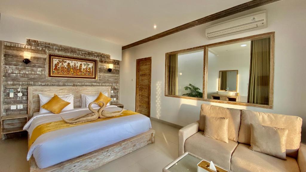 a bedroom with a large bed and a couch at The Kama in Nusa Penida