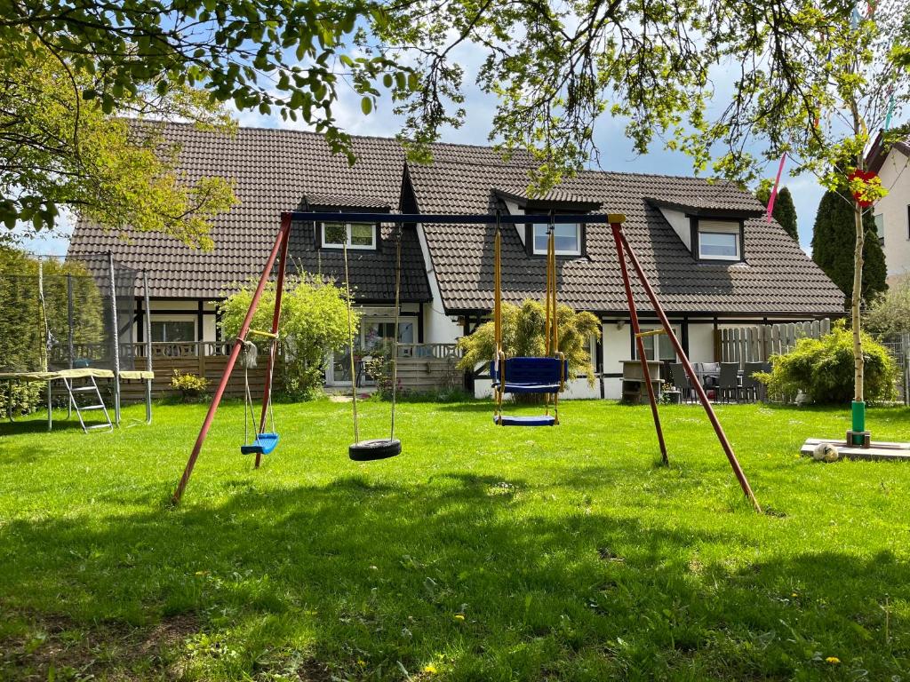 einen Hof mit Schaukeln vor einem Haus in der Unterkunft Familienwohnung "Gartenblick" auf 2 Etagen in Aalen