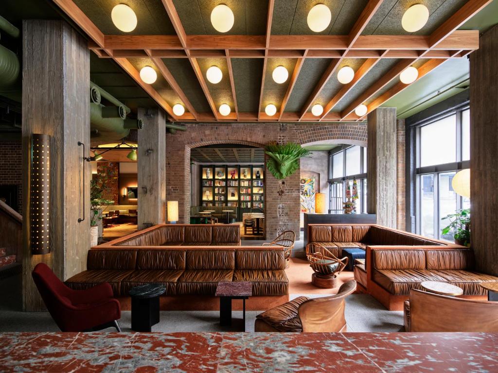 a lobby with leather couches and a bar at Ace Hotel Sydney in Sydney