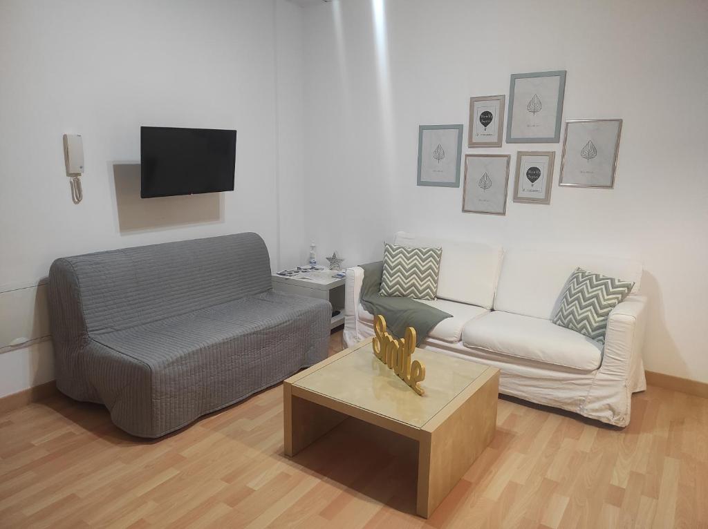 a living room with a couch and a coffee table at Amplio estudio en centro y playa Victoria 13 in Málaga