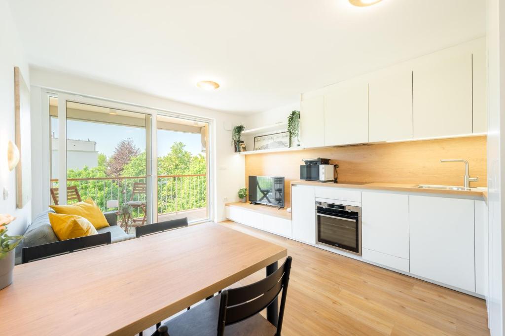 une cuisine avec une table en bois et une grande fenêtre dans l'établissement APARTMENT 396, à Ljubljana