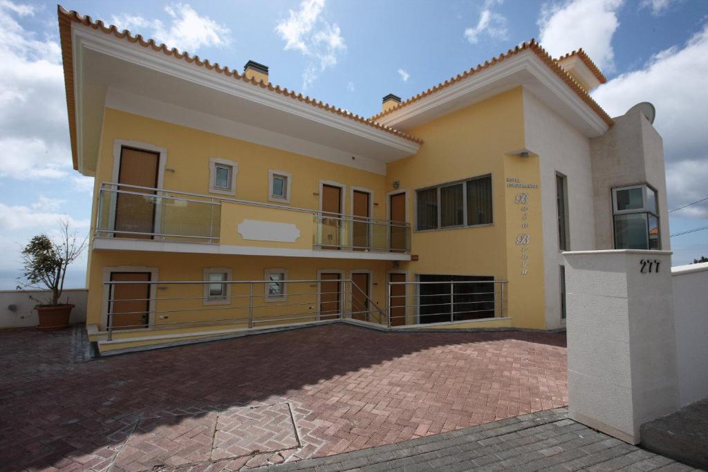 Una gran casa amarilla con una gran entrada en Hotel Apartamentos Baia Brava, en Gaula
