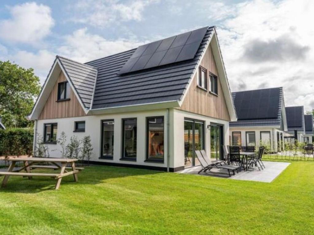 een huis met zonnepanelen op het dak bij Appealing Holiday Home in De Koog Texel with Sauna in Westermient