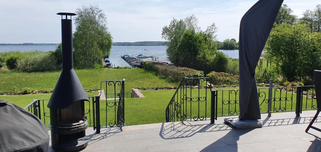 einen schwarzen Zaun mit Blick auf einen Wasserkörper in der Unterkunft Seeblick (optional mit Boot) in Plau am See