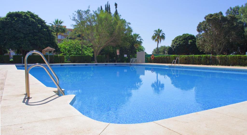 duży niebieski basen z metalową poręczą w obiekcie Parque de la Paloma Area - Benalmadena Costa w mieście Benalmádena