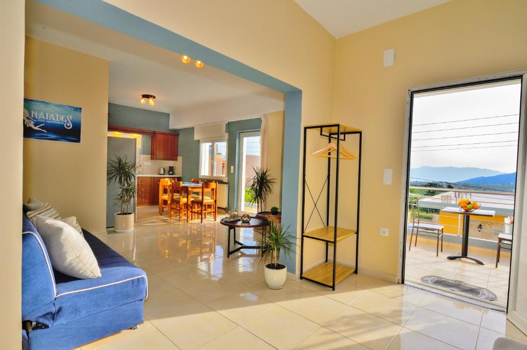 a living room with a blue couch and a dining room at Naiades Summer House I in Plátanos