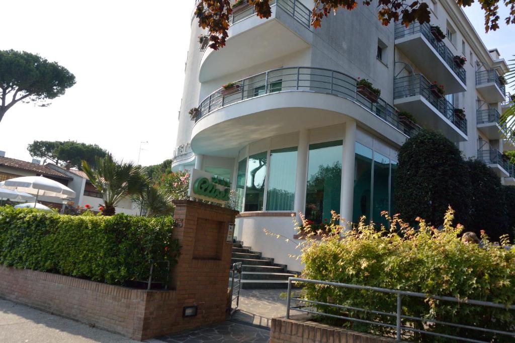 un gran edificio blanco con escaleras y balcón en Hotel Alisei en Lignano Sabbiadoro