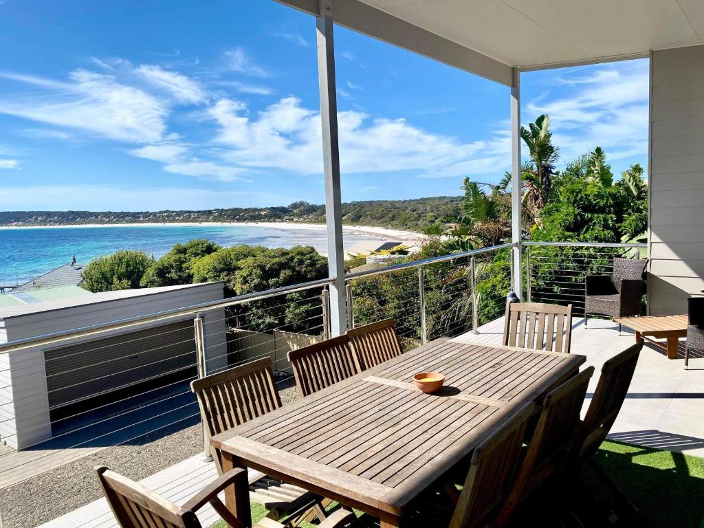 a wooden table on a balcony with a view of the ocean at Annies View in Emu Bay
