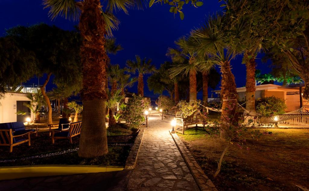 a park with palm trees and lights at night at CHARM BEACH HOTEL in Akyarlar