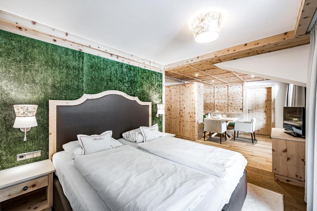 a bedroom with a large bed with a green wall at Vierjahreszeiten in Hintertux