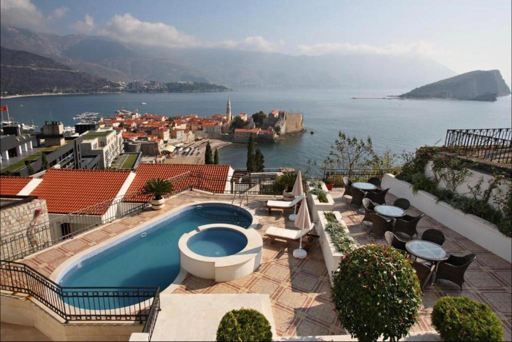 a swimming pool on top of a building with a view of the water at Vidikovac Budva in Budva