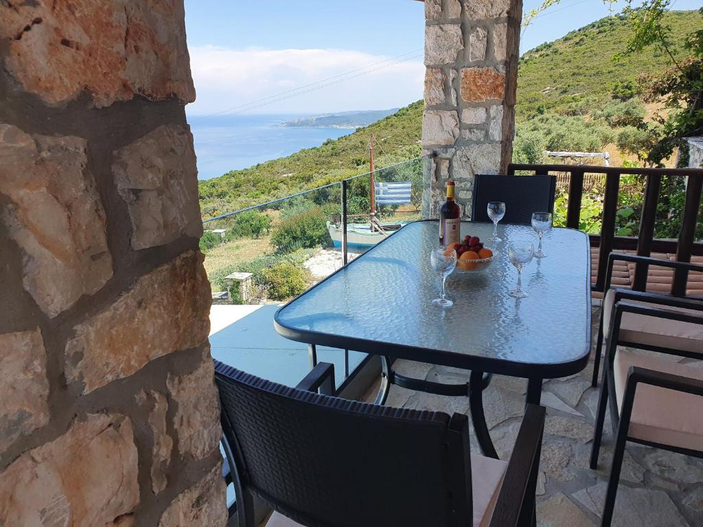 a table on a balcony with a view of the ocean at Nireas : Stone Villa in Zakynthos