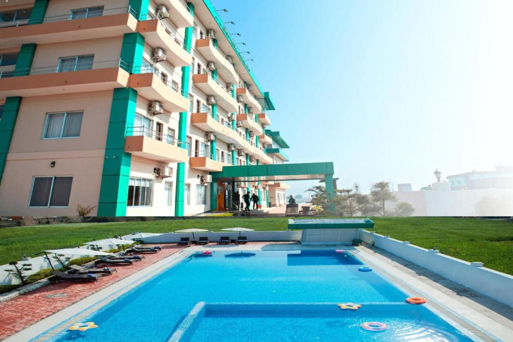 una piscina frente a un edificio en Gautam Buddha Airport Hotel, en Bhairāhawā