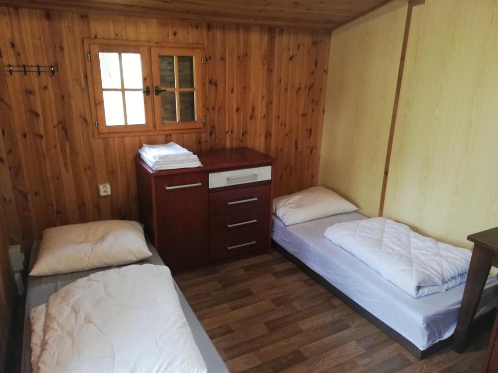 a room with two beds and a cabinet and a window at Sport kemp Ejpovice in Ejpovice