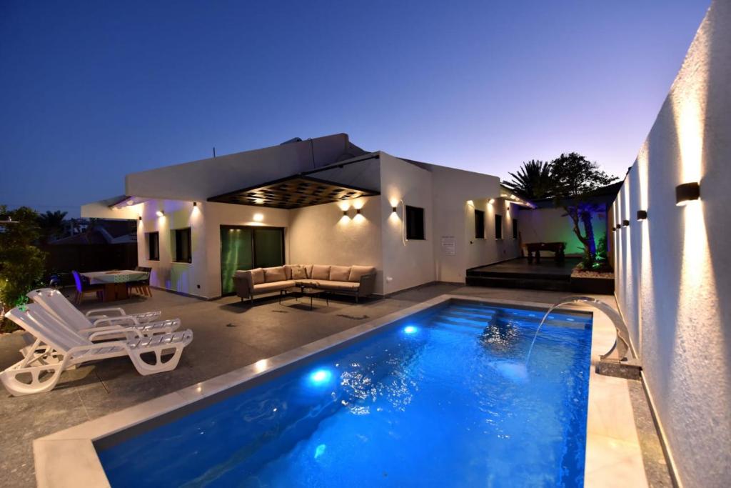 a swimming pool in front of a house at White-Private pool Luxury Villa Eilat in Eilat