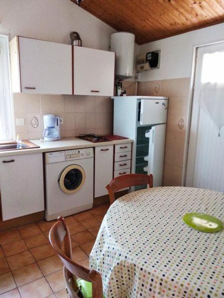 a kitchen with a table and a kitchen with a refrigerator at Gîte 2 personnes, proche mer in Challans