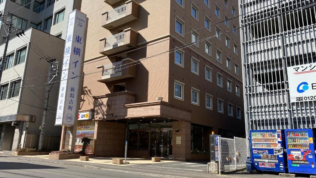 ein Gebäude in einer Stadtstraße mit hohen Gebäuden in der Unterkunft Toyoko Inn Niigata Furumachi in Niigata